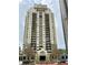 High-rise condo building featuring a well-manicured entrance and multiple balconies on each level at 795 Hammond Dr # 1908, Atlanta, GA 30328