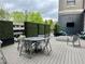 Outdoor patio with gray composite deck, a modern metal table and chairs, green hedges and a tv at 795 Hammond Dr # 1908, Atlanta, GA 30328