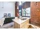 Bright kitchen island with stainless steel sink, light wood cabinets, stone countertop and modern fixtures under high ceilings at 195 Arizona Ne Ave # 203, Atlanta, GA 30307