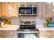 A stylish kitchen featuring wooden cabinets, stainless steel appliances, a modern range hood, and decorative backsplash at 195 Arizona Ne Ave # 203, Atlanta, GA 30307