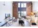 Spacious living room with brick wall, high ceilings, modern furnishings, and kitchen view at 195 Arizona Ne Ave # 203, Atlanta, GA 30307