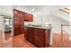 Kitchen island featuring dark wood cabinets, ample storage, and hardwood floors, creating a functional and beautiful focal point at 282 Autry Mill Ln, Suwanee, GA 30024