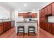 Open kitchen features dark cabinets, an island with bar seating and stainless-steel appliances, creating a functional and stylish space at 282 Autry Mill Ln, Suwanee, GA 30024