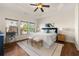 Bright main bedroom with a tray ceiling, three windows, and a large bed at 282 Autry Mill Ln, Suwanee, GA 30024