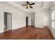 Bright main bedroom with hardwood floors, tray ceiling, and multiple doorways leading to a bathroom and closet at 282 Autry Mill Ln, Suwanee, GA 30024