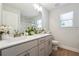 Bright bathroom featuring a double vanity with white countertops, modern fixtures, and wood-look floors at 2860 Windsor Knoll Dr, Dacula, GA 30019
