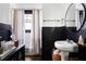 Chic bathroom featuring white walls, black wainscoting, a round mirror, and a tub shower with a beige curtain at 836 Dill Sw Ave, Atlanta, GA 30310