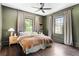Charming bedroom featuring dark wood floors, olive-green walls, black trim windows and unique ceiling fan at 836 Dill Sw Ave, Atlanta, GA 30310