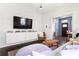 Cozy living room with dark wood floors and bright entryway, featuring white cabinets and a large television at 836 Dill Sw Ave, Atlanta, GA 30310