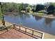 Private deck view overlooking a beautiful backyard with mature trees and a lake at 870 Longstone Lndg, Alpharetta, GA 30022