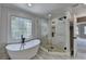This bathroom boasts a large glass shower and a standalone tub by the window at 870 Longstone Lndg, Alpharetta, GA 30022