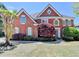 Charming brick home featuring symmetrical design, lush landscaping, and inviting entrance at 870 Longstone Lndg, Alpharetta, GA 30022