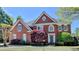 Charming brick two-story home with manicured landscaping and a symmetrical facade at 870 Longstone Lndg, Alpharetta, GA 30022