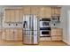 Kitchen with stainless steel refrigerator, double oven and tan wood cabinetry at 870 Longstone Lndg, Alpharetta, GA 30022