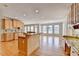 Kitchen with an island, wood cabinets, tile backsplash, and hardwood floors at 870 Longstone Lndg, Alpharetta, GA 30022