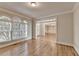 Bright living room showcasing hardwood floors, large windows, and seamless access to other rooms at 870 Longstone Lndg, Alpharetta, GA 30022