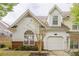 Charming home featuring a one-car garage, lovely landscaping, and large arched window offering natural light at 1052 Pike Forest Ct, Lawrenceville, GA 30045