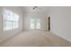 A light-filled main bedroom with french doors, a ceiling fan, and neutral carpeting at 1052 Pike Forest Ct, Lawrenceville, GA 30045