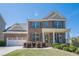 Charming two-story brick home with a well-manicured lawn and a classic front porch at 1060 Crescent Ridge Dr, Buford, GA 30518