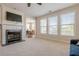 Well-lit living room with fireplace, large windows, and a view into the dining room at 1060 Crescent Ridge Dr, Buford, GA 30518