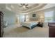 Large primary bedroom featuring a tray ceiling, two windows, and carpet floors at 1060 Crescent Ridge Dr, Buford, GA 30518