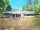Back of the house featuring a sunroom, and neutral siding, set in a partially wooded area at 35 Belmont Way, Covington, GA 30016