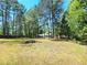 The backyard is spacious, showcasing mature trees and a glimpse of the house nestled among them at 35 Belmont Way, Covington, GA 30016