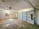 A garage featuring a roll-up door, concrete flooring and peeling paint needing repair at 35 Belmont Way, Covington, GA 30016