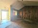 Living room featuring wood paneling, exposed walls, and a view into the front yard at 35 Belmont Way, Covington, GA 30016
