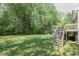 A green grassy backyard is complemented by a deck with a staircase at 2374 Rolling Acres Sw Dr, Conyers, GA 30094