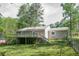 Exterior view of a charming home with a spacious backyard, raised deck and mature trees at 2374 Rolling Acres Sw Dr, Conyers, GA 30094