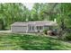 Charming single-story home featuring a covered front porch and surrounded by lush trees and green lawn at 2374 Rolling Acres Sw Dr, Conyers, GA 30094