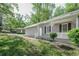 Side view of the home with a lush lawn, featuring a charming front porch and black shuttered windows at 2374 Rolling Acres Sw Dr, Conyers, GA 30094