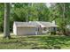 Quaint single-story home with a well-maintained lawn, a covered porch, and a detached garage at 2374 Rolling Acres Sw Dr, Conyers, GA 30094