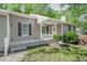 Close-up of the home's entrance, showcasing a covered porch with white lattice and a well-maintained lawn at 2374 Rolling Acres Sw Dr, Conyers, GA 30094