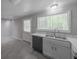 Well-lit kitchen featuring stainless steel sink, dishwasher, and backyard view at 2374 Rolling Acres Sw Dr, Conyers, GA 30094