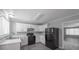 Spacious kitchen has white cabinets, newer black appliances and modern touches at 2374 Rolling Acres Sw Dr, Conyers, GA 30094