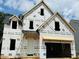 Unfinished two-story house with visible framework showcasing future residence with a 2-car garage and covered front entrance at 3350 Hillshire Dr, Cumming, GA 30028