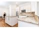 Well-lit kitchen boasting an island, stainless steel appliances, granite countertops, and hardwood floors at 3759 Wescott Ne Cv, Brookhaven, GA 30319