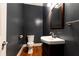 This half bathroom features dark blue walls, hardwood floors, and a dark wood vanity with a white sink at 3759 Wescott Ne Cv, Brookhaven, GA 30319