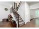 Elegant staircase with carpeted steps and dark wood railing, leading to the upper level at 5638 Berney Cir, Powder Springs, GA 30127