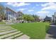 Backyard view of modern home with a large manicured lawn and a barbecue area at 127 Ravenhurst Dr, Fayetteville, GA 30214
