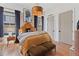 Primary bedroom featuring a brick accent wall, modern lighting, and hardwood floors at 127 Ravenhurst Dr, Fayetteville, GA 30214