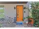A close-up of the home's bright orange front door with modern hardware and charming welcome mat at 127 Ravenhurst Dr, Fayetteville, GA 30214