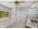 Bright bathroom with dual sinks, a soaking tub, and a large window overlooking a wooded area at 215 The Farm Rd, Mcdonough, GA 30252