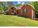 Charming single-Gathering home with brick facade, manicured lawn, and mature trees at 215 The Farm Rd, Mcdonough, GA 30252