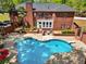 Expansive backyard featuring a brick home, an in-ground pool, a balcony, and a well-manicured lawn at 215 The Farm Rd, Mcdonough, GA 30252
