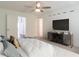 Inviting bedroom features neutral tones, a ceiling fan, and a modern entertainment center for comfort and style at 3409 Catalan Aly, Decatur, GA 30032
