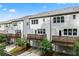 Back exterior of multi-Gathering homes featuring individual decks and garages, set against a partly cloudy sky at 3409 Catalan Aly, Decatur, GA 30032
