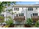 Back exterior of multi-Gathering homes featuring individual decks and garages, surrounded by lush greenery at 3409 Catalan Aly, Decatur, GA 30032